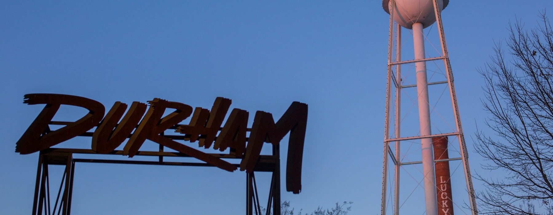 a blue sky with a water tower and sign