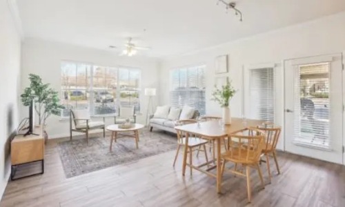 a living room with a couch, tables and chairs