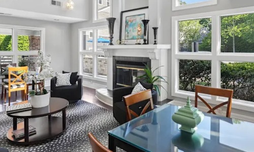 a clubroom with a fireplace, tables and chairs