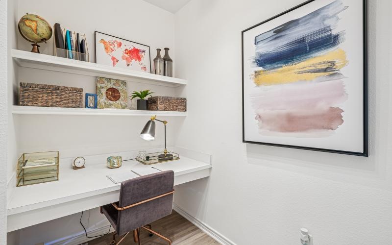 a room with a desk and shelves